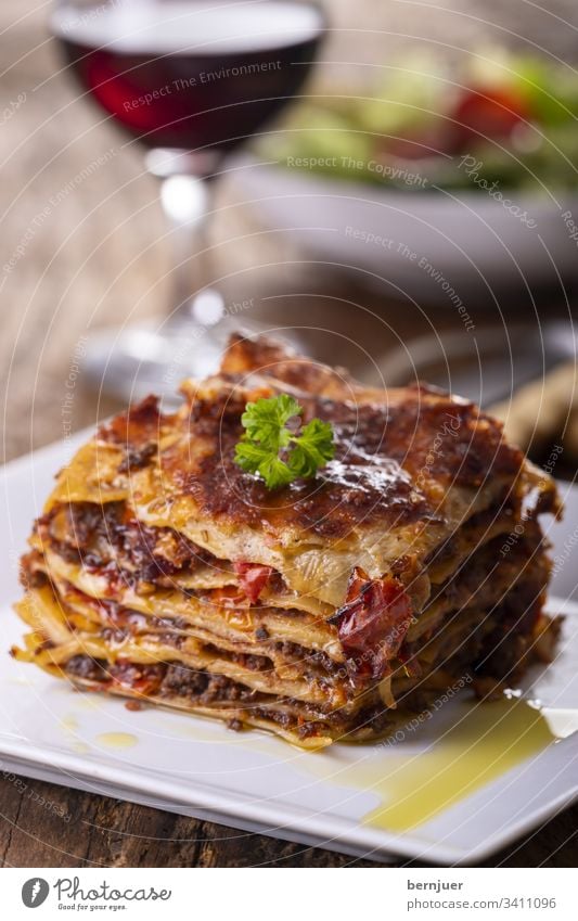 Lasagne on a plate Red wine Lettuce grissini Summer Vine White Wood Rustic Minced meat herbaceous Bolognese Bolognaise Crockery Mixed Tasty Mozzarella Portion