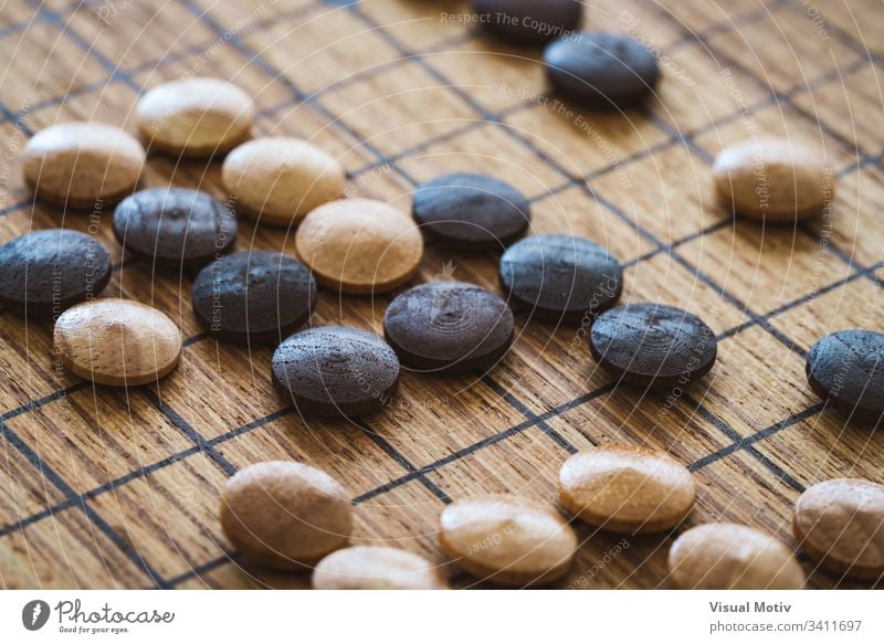 Wooden mixed chips over a board of the traditional chinese game called GO abstract ancient closeup color culture detail entertainment fun go indoor interior