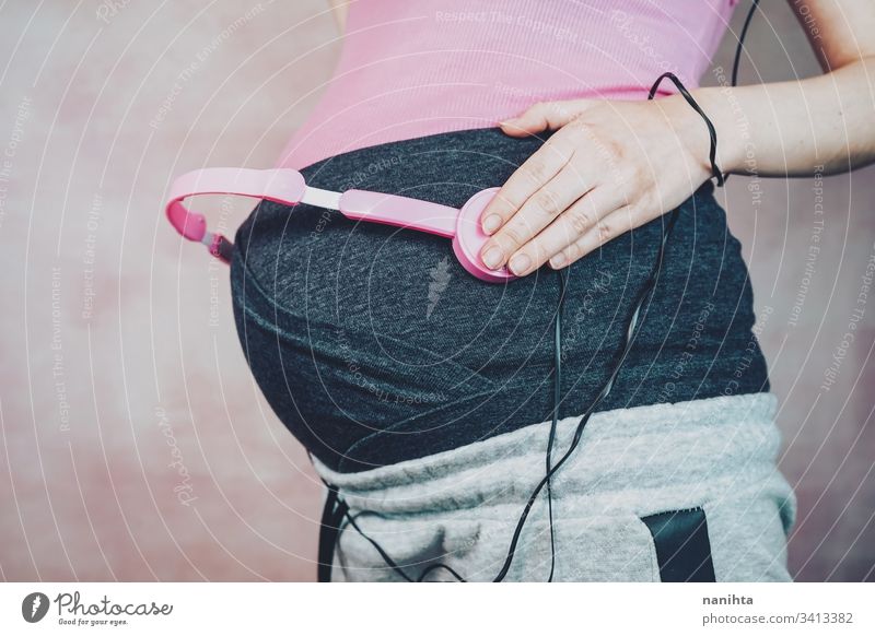 Young mother put music to her baby in her belly during pregnancy pregnant mom headphones headset development growth life health healthy leiure listen