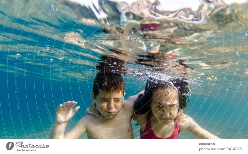 Two kids with closed eyes diving into the sea action active activity beach beautiful blue boy child cute dive diver enjoy family friends friendship fun girl