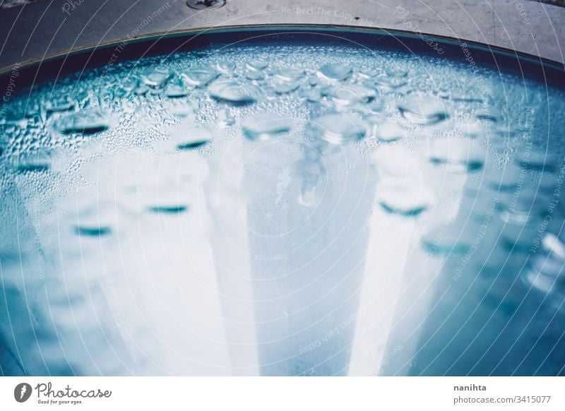 Abstract image of raindrops over a glass water crystal wet clean backdrop wallpaper fresh freshness cold rainy rain drops blue tones reflection light focus blur