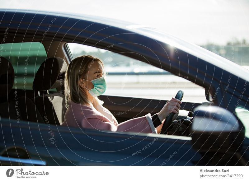 Woman in protective mask driving a car on road. Safe traveling. automobile breathing city coronavirus covid-19 dashboard destination drive driver driveway