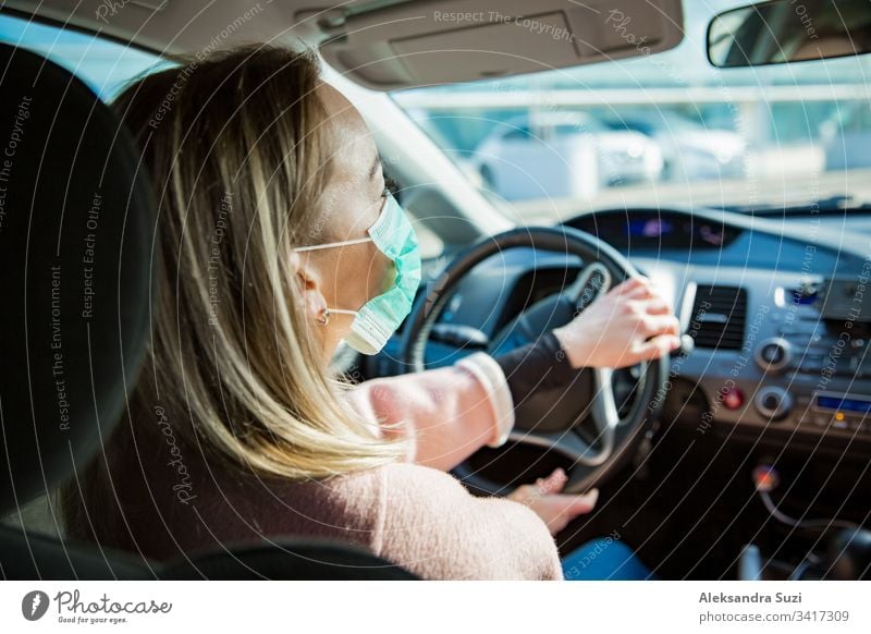 Woman in protective mask driving a car on road. Safe traveling. automobile breathing city coronavirus covid-19 dashboard destination drive driver driveway