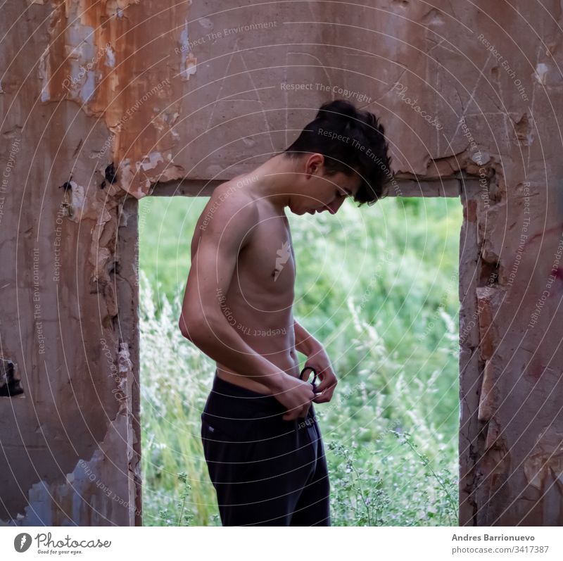 Young boy in an abandoned house fashion close lifestyle homelessness pair sport male poverty up building ruined destroyed ruins activity trend man dark