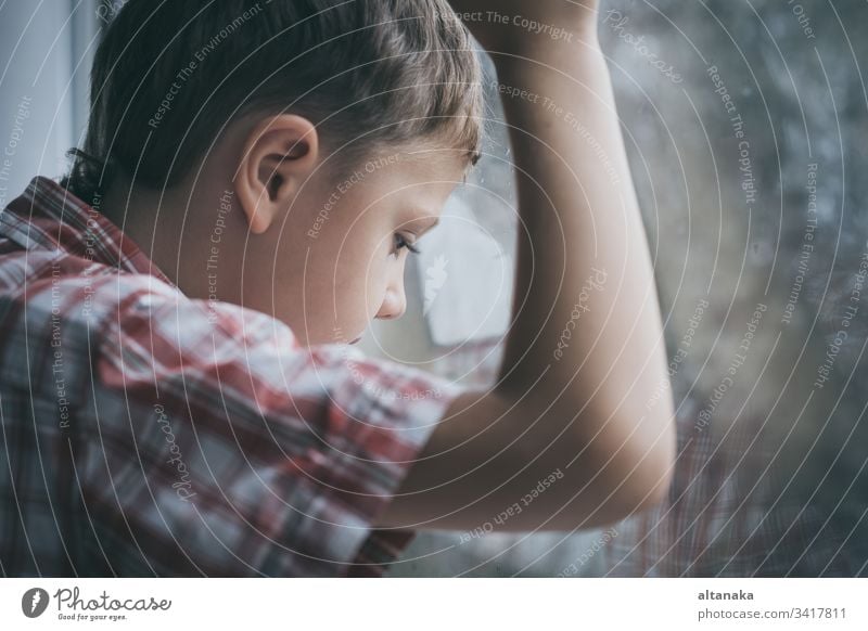 portrait one sad little boy sitting near a window innocence bad sorrow issues youth loss problem lost depressed serious lonely grief forgiveness anxiety unhappy