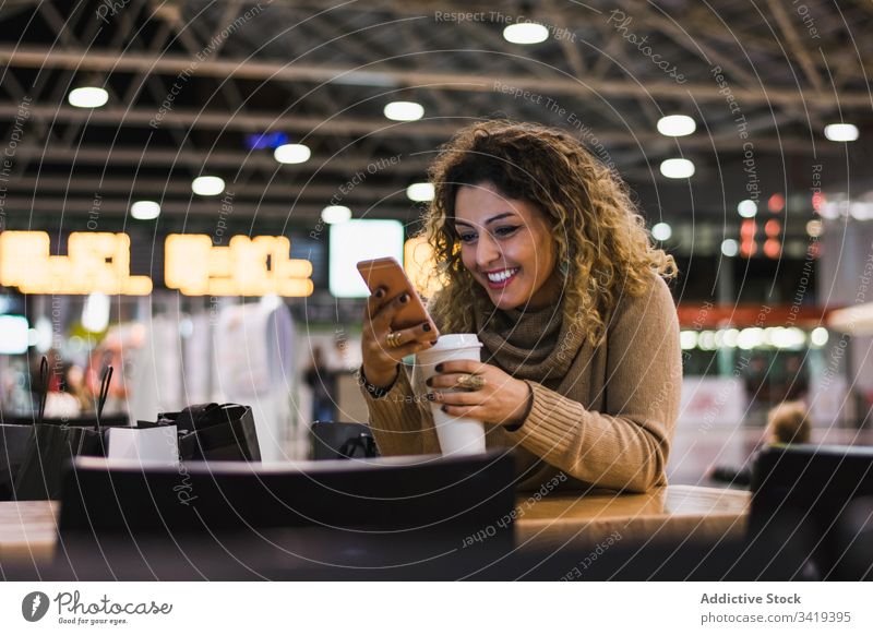 Woman drinking coffee and on the mobile phone in airport woman smartphone beverage cup female casual to go cellphone modern relax break technology takeaway hot