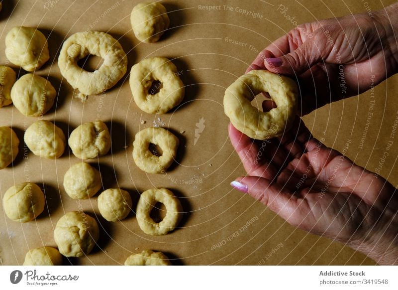 Crop female making donuts from dough woman cook table ring shape home pastry food fresh snack bakery dessert sweet meal round cuisine gourmet tradition culinary