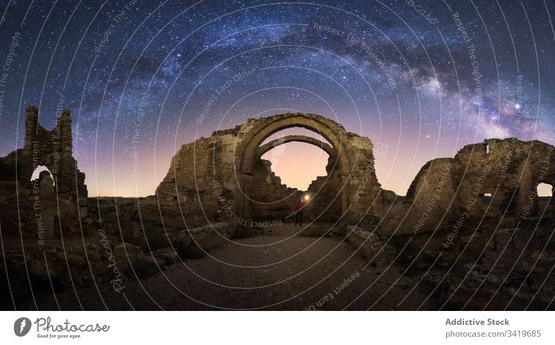 Unrecognizable tourist exploring old ruins at night explore traveler sightseeing remain ancient castle milky way starry abandoned ruined architecture medieval