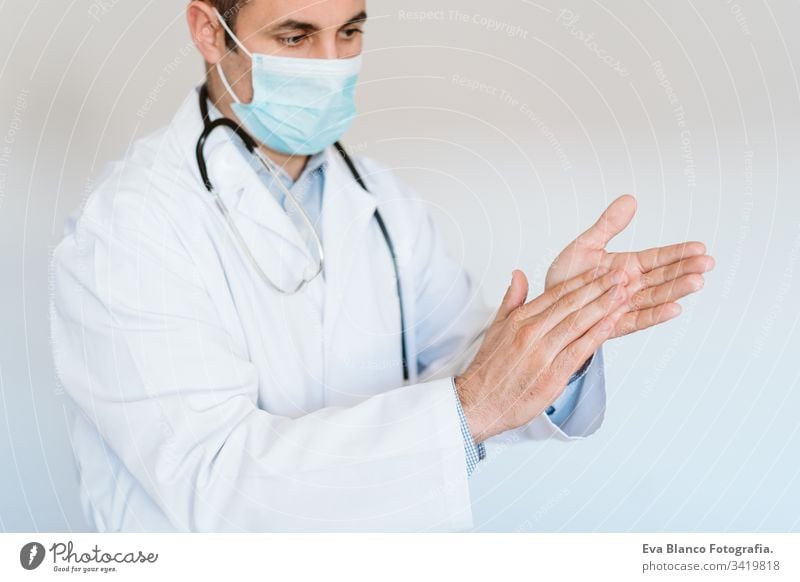 caucasian doctor wearing protective mask and gloves indoors. Using an alcohol gel or antibacterial disinfectant. Hygiene and corona virus concept man
