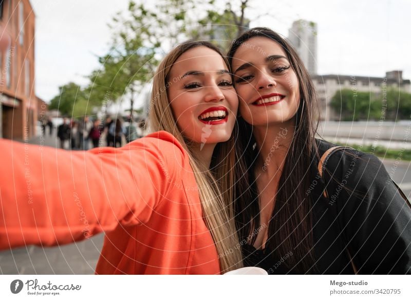 Two young friends taking a selfie outdoors. portrait two cheerful street adult hangout girls travel woman urban leisure joy style cool enjoyment positive