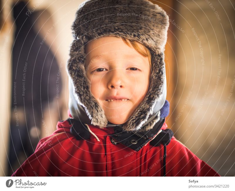 Little boy in snowsuit making funny expressions winter child happy little look face eyes white caucasian kid cold hat cap cute season playing clothing mountain