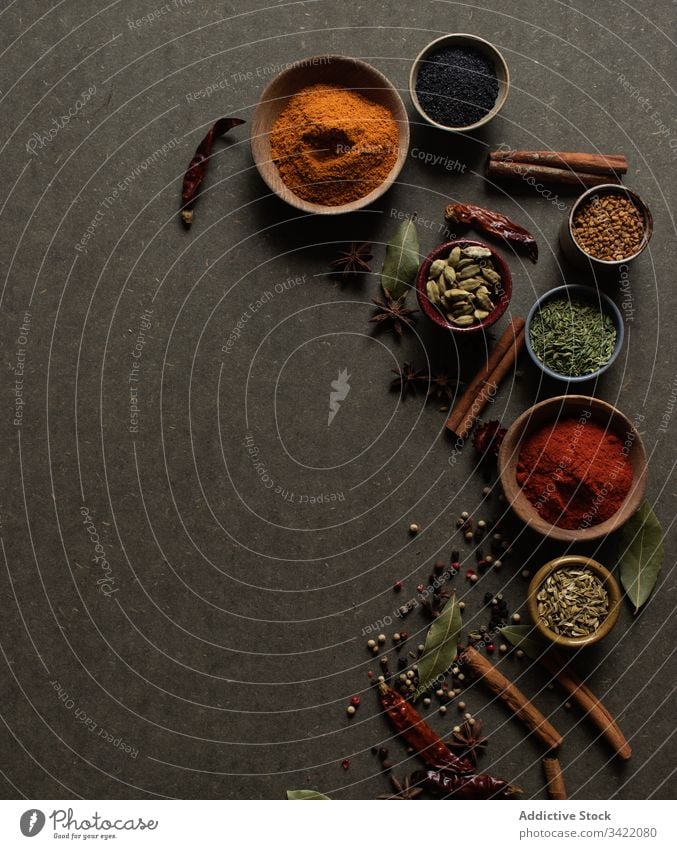 Various spices on gray background natural aromatic set assorted various powder seed dry food paprika pepper cinnamon peppercorn chili bay leaf stick bowl pot
