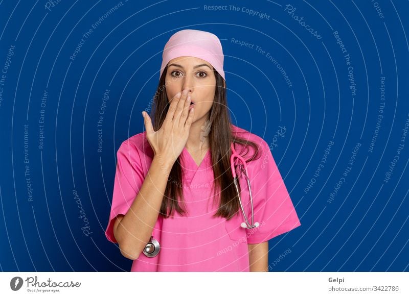Young doctor with a pink uniform disease illness woman breast cancer mute cover mouth silence happy laugh forbid surprised surprising health female care review