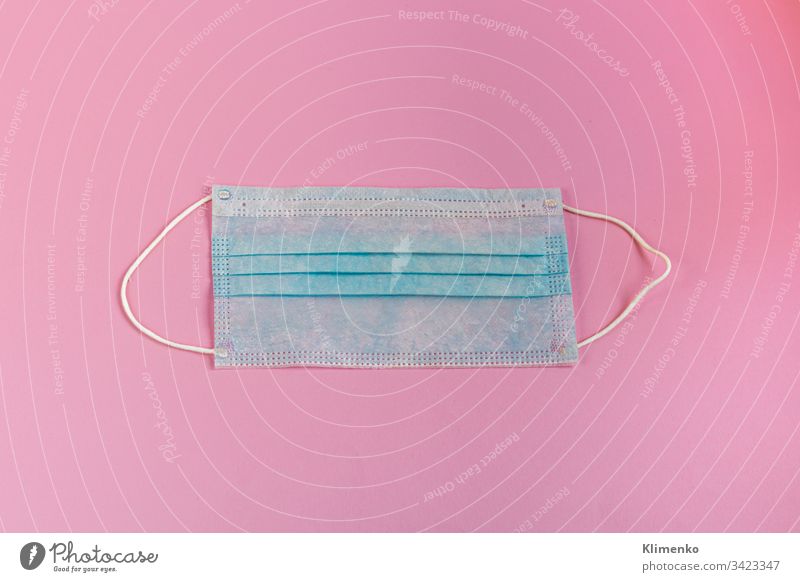 A sanitary protection mask helps prevent the infiltration of the Corona virus or Covid-19 and other diseases. Blue on pink. View from above. coronavirus blue