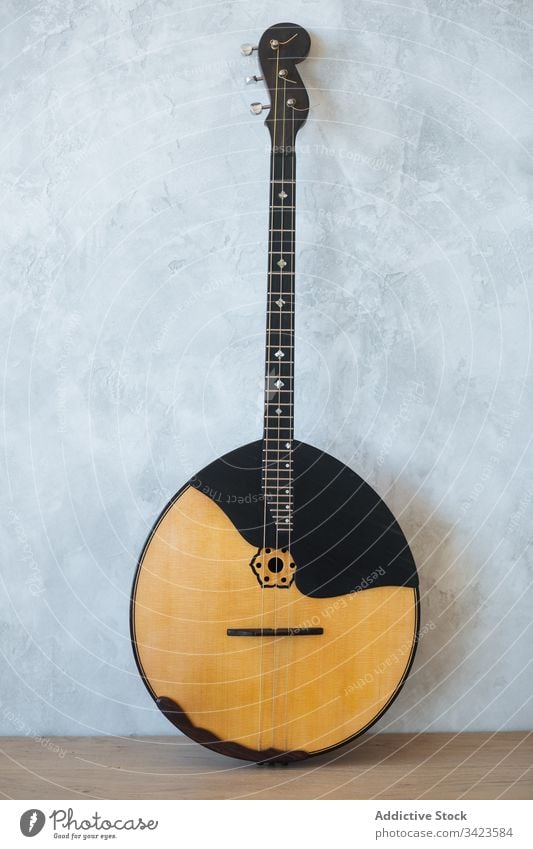 Classic wooden banjo against wall guitar acoustic musician instrument grey classic string hobby equipment modern detail skill harmony tune culture entertain