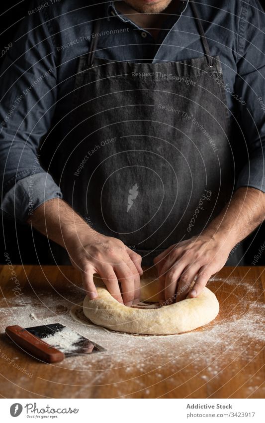 Baker forming bread in kitchen dough prepare food cook chef round baker man hole pastry table culinary homemade tasty delicious cuisine recipe process