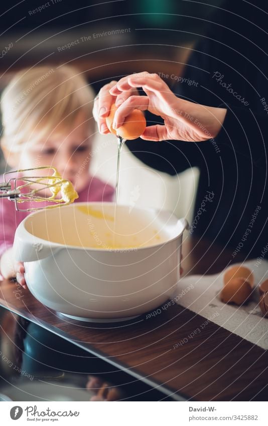 Baking a cake Child with mother Mother Cake eggs Parenting observantly watch Study Girl Toddler Infancy Deep depth of field Interior shot Human being Hand