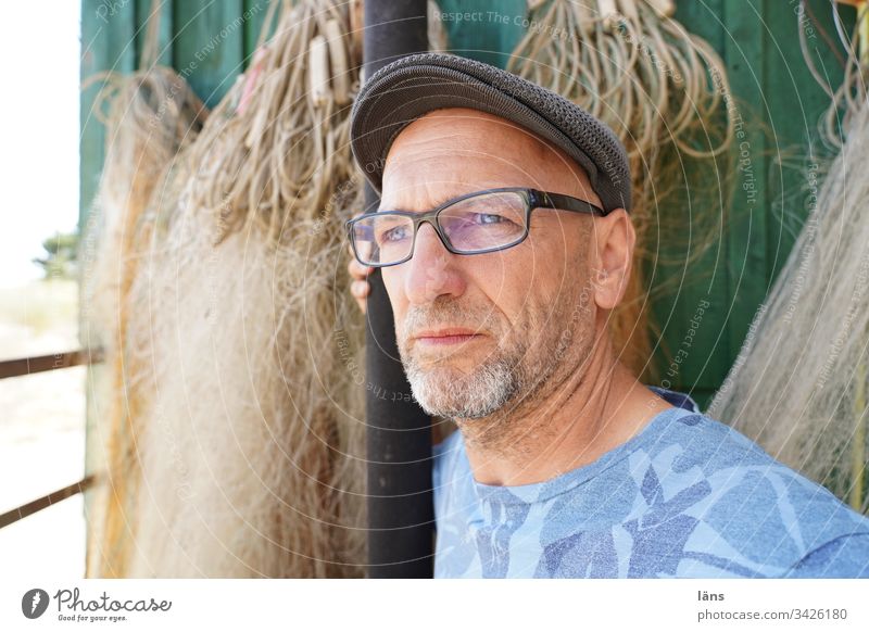 pensively man in front of fishing nets Man Senior citizen Meditative attentiveness Caution