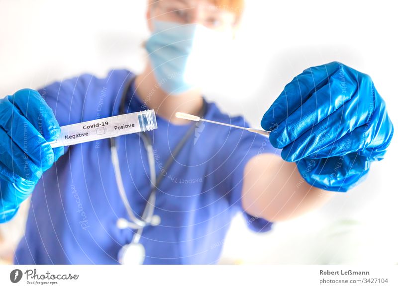 a doctor holds a smear tube with coronavirus in her hand Swab tubes Doctor covid-19 Mask Proof Positive Negative 2019-nCov pathogenic Sars-CoV-2 Hand chopsticks
