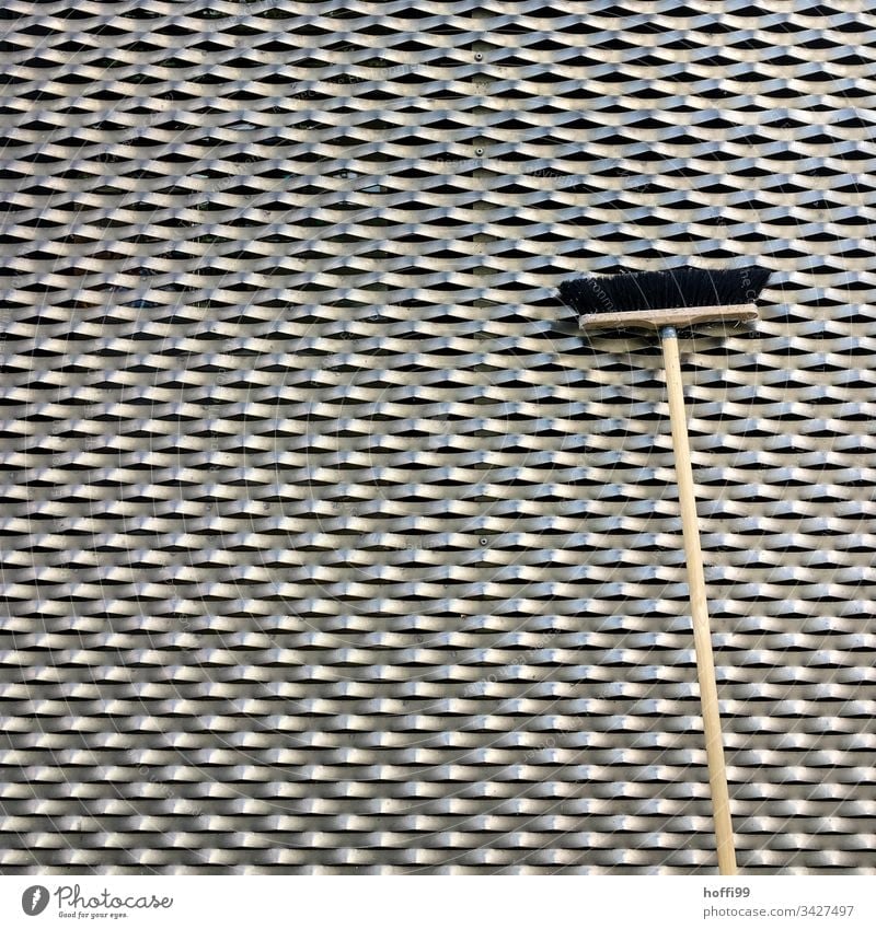Broom in front of a metal facade Broomstick Broom closet Structures and shapes cladding of facades Facade Architecture structure Metal Honeycomb pattern Waves