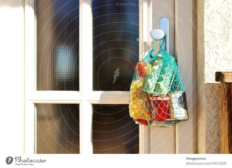 contactless purchase delivery during quarantine. shopping bag with goods and food hangs on the front door, neighbourhood support - concept for quarantine period due to coronavirus infection Covid-19