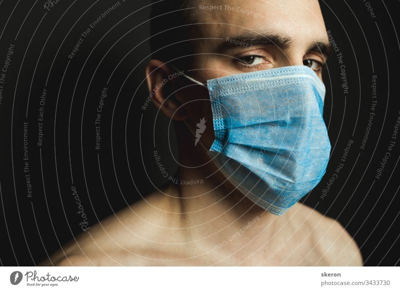 Portrait of a man with medical facial mask who is concerned about preventing pandemic coronavirus on a gray background. quarantine and pandemic concept. Man wearing aseptic mask to prevent illness.
