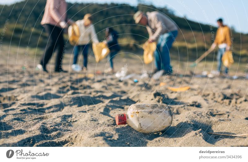 Volunteers cleaning the beach plastic bottle family volunteering dirty garbage bags ecological conscience group tools environment child people male collect