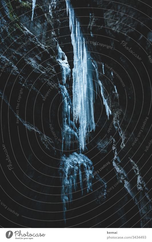 Icicle in canyon Winter Cold Ice Canyon rock Dark somber icily Hang Stone Large gigantic clammy Nature natural beauty Frozen Water Blue