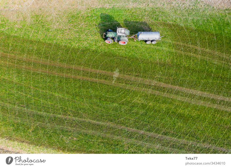 tractor spraying cow dung from above #3 farming tractor agriculture agricultural meadow field grass modern modern agriculture modern machine farming machine