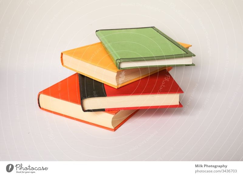 A stack of colourful books on a white background vertical nobody color photo image styled stock copyspace space for text copy space neutral wall dictionary