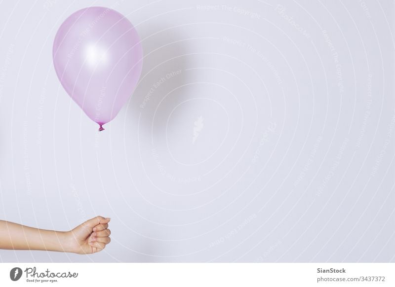 Womans hand holds balloons in a white background isolated helium bunch color colorful pink purple decoration holiday celebration joy party celebrate fly float