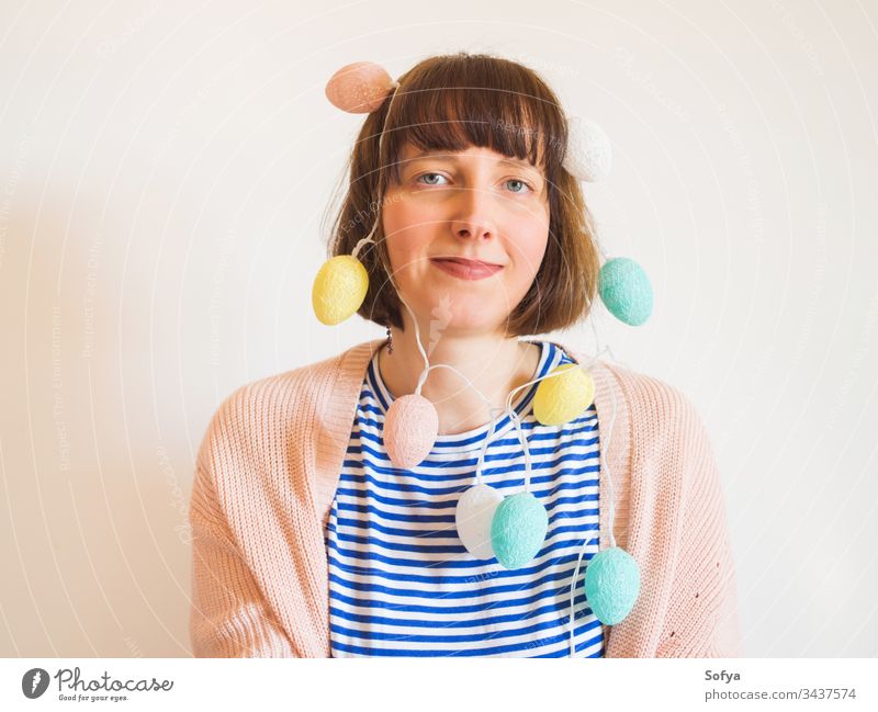 Easter concept female portrait with egg lights easter bunny decor funny celebrate festive party spring pastel colors holiday woman young girl face smiling