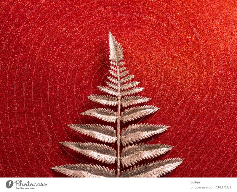 Glitter shiny red background with golden branch glitter christmas silver tropical plant winter cold snow classic abstract festive new year metallic surface