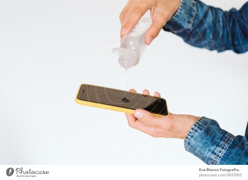 close up view of a woman cleaning mobile phone with disinfectant. Hygiene and coronavirus covid-19 concept corona virus hygiene screen anti bacterial soap