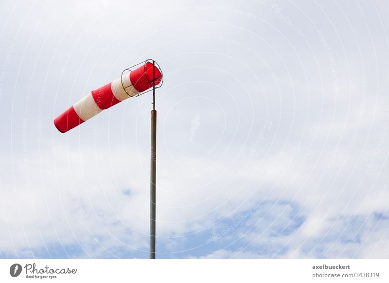 windsock or air sock direction windy wind cone wind sleeve air sleeve high winds weather speed sky meteorology storm stormy red white stripes striped indicator