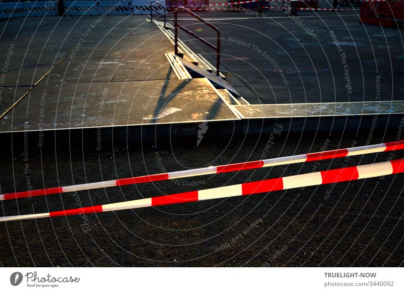 Skateboard arena in the evening sun, cordoned off with red and white flutterband | Corona Thoughts Playground Sporting grounds Concrete floor Evening sun