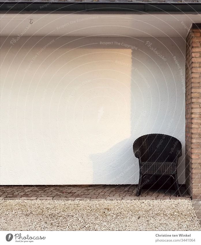 Lonely armchair on a house wall Loneliness Armchair Seating Sun Shadow light colours Wait Furniture Subdued colour Day Gloomy Brown White social distancing