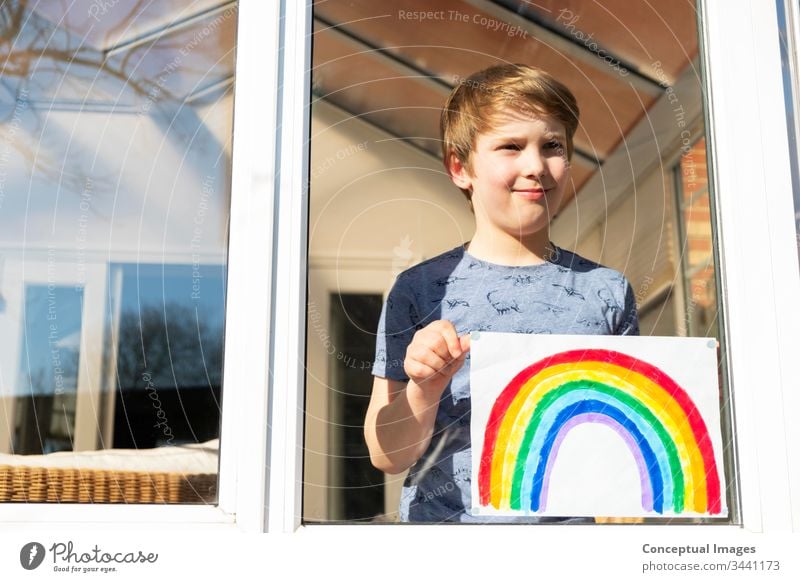 Caucasian boy holding an image of a rainbow childhood drawing hope daydreaming inspiration aspiration caucasian young kid artist colorful activity kids artistic