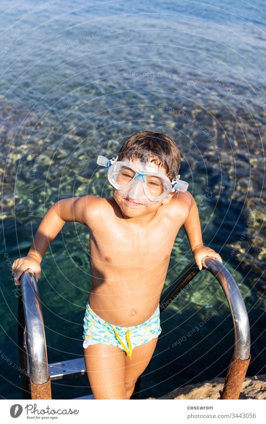 Little boy on a pool ladder going down to bathe in the sea amandakis beautiful blue child childhood clear climbing coast crystal cute diving fun goggles greece