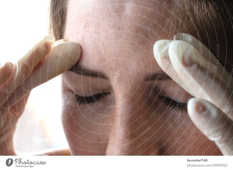 Female with latex gloves looks down stressed by coronavirus, covid-19 self isolation or depression portrait close-up female medical medicine person health
