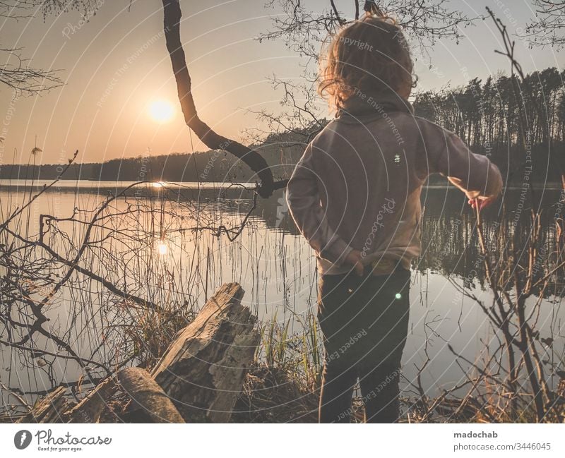 Child stands at the lakeside at sunset and looks into the future Sunset Lake Water Nature Forest Boy (child) Sunlight Back-light romantidch Future Lakeside