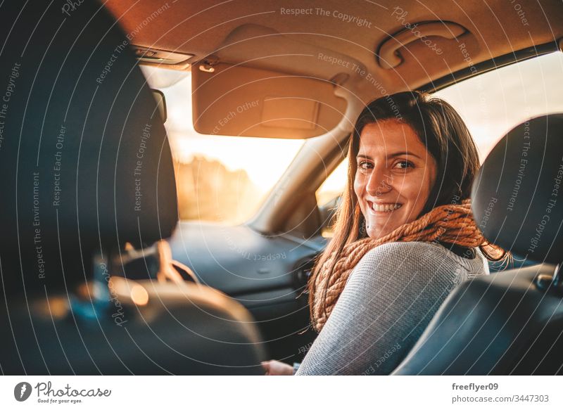 Portrait of a young woman on the frontseat of a car auto automobile beautiful business cheerful cute dealership drive driver emotion excited family girl