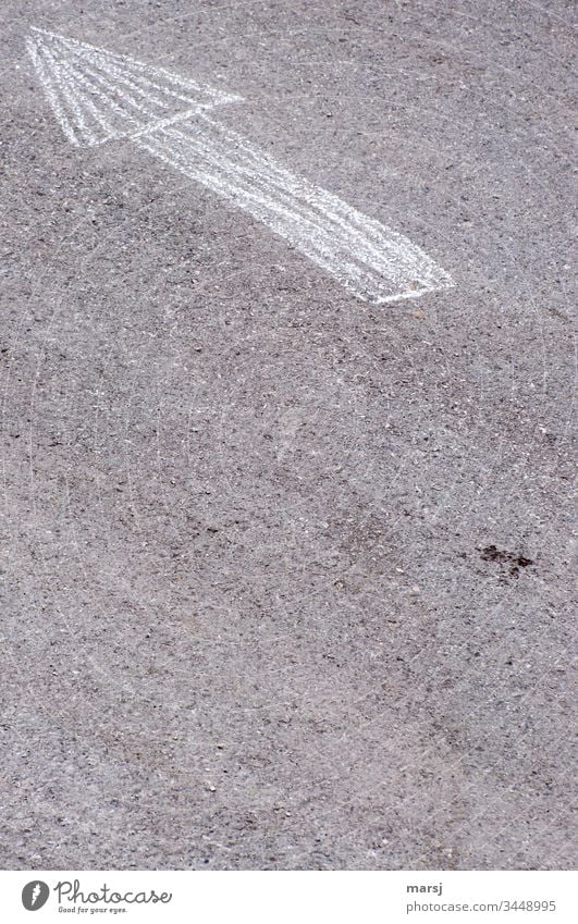 An arrow, drawn with chalk, on asphalt road, pointing to the upper left corner. Arrow groundbreaking Direction Asphalt Clue Subdued colour Contrast