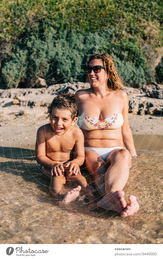 Mother and son on the shore of a Greek island active beach beautiful boy child childhood coast copy space enjoy family female fun funny glasses greece happiness
