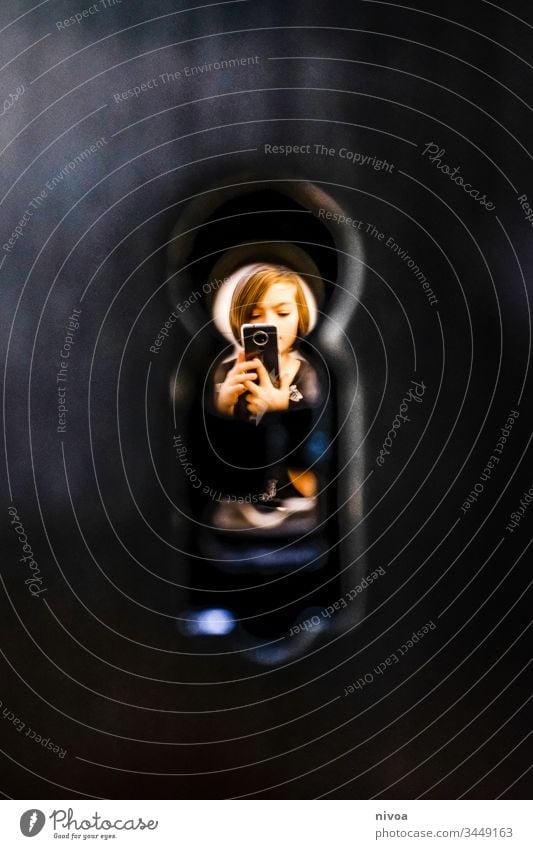 young through the keyhole Boy (child) Keyhole mobile Playing Observe Spy Copy Space left Detail Colour photo Interior shot Looking Human being Eyes Surveillance