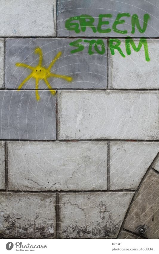 Green Storm with sun as lettering and icon sprayed on a grey wall with bricks. Climate change green Greenstorm Gale Wall (building) Facade Wall (barrier) Sun