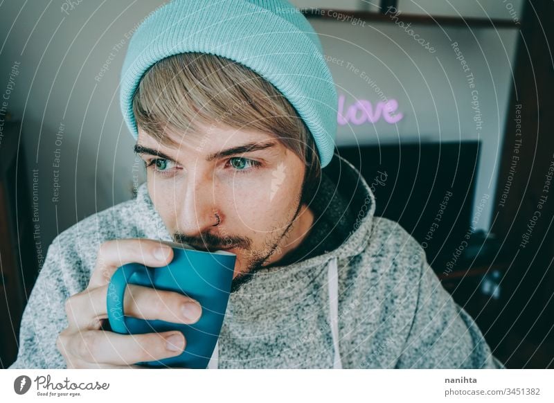Young man enjoying a cup of coffee at home male cozy isolated quarantine blue attractive handsome guy casual wear pajama tea black tea drink drinking hot drink