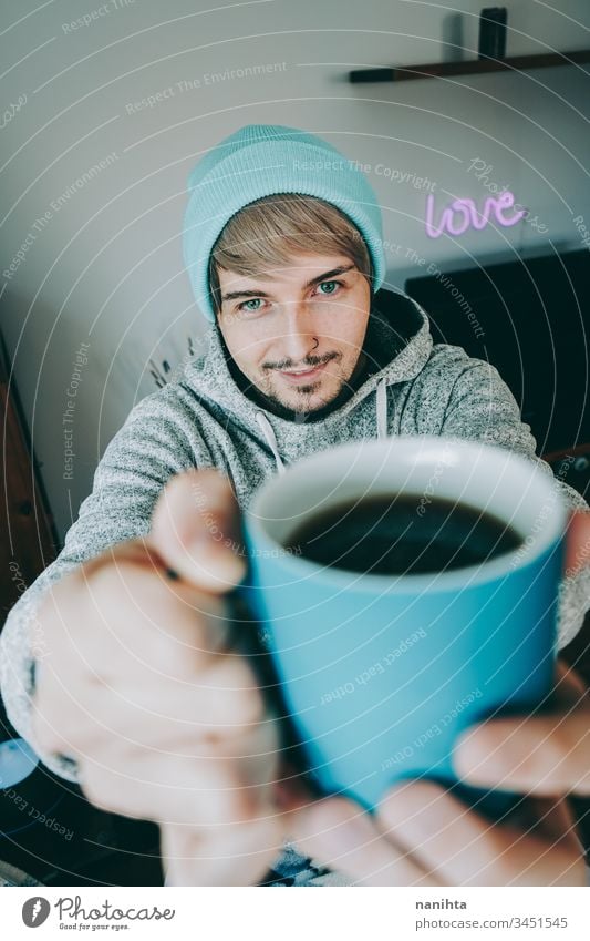 Young man enjoying a cup of coffee at home male cozy isolated quarantine blue attractive handsome guy casual wear pajama tea black tea drink drinking hot drink