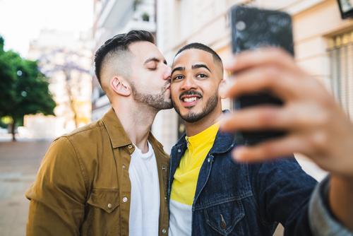 Gay couple taking a selfie in the street. gay love relationship mobile phone date lovely partnership positive city freedom life young pride dating looking