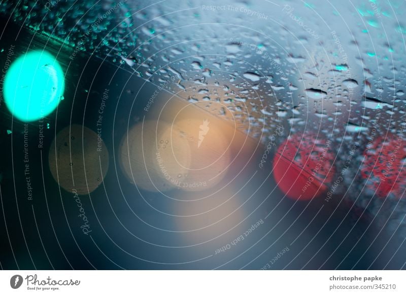 two-part Bad weather Rain Transport Car Water Wet Weather Divided Drops of water Windscreen Windscreen wiper Traffic light Point of light Colour photo Close-up